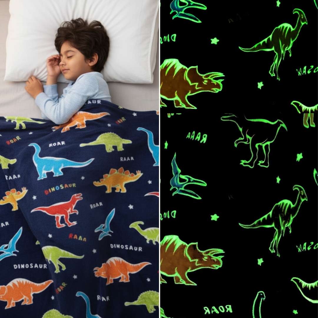 Child sleeping under a navy blue Famyo dinosaur-themed glow-in-the-dark blanket, shown glowing with green dinosaur outlines in the dark.