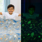 A child with space-themed bedding, shown under normal lighting and in its glowing-in-the-dark effect.
