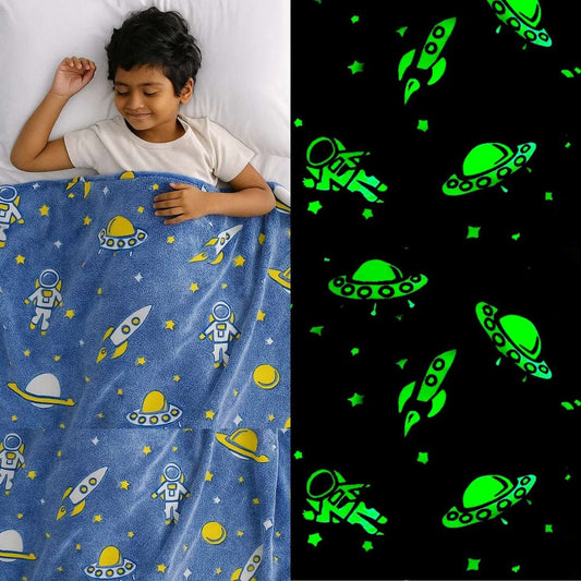 Child sleeping under a blue space-themed blanket with green glow-in-the-dark patterns.