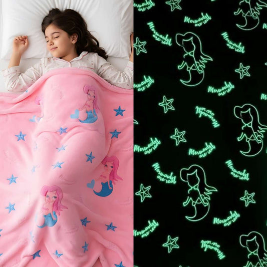 Pink mermaid-themed blanket with glow-in-the-dark design on a black background