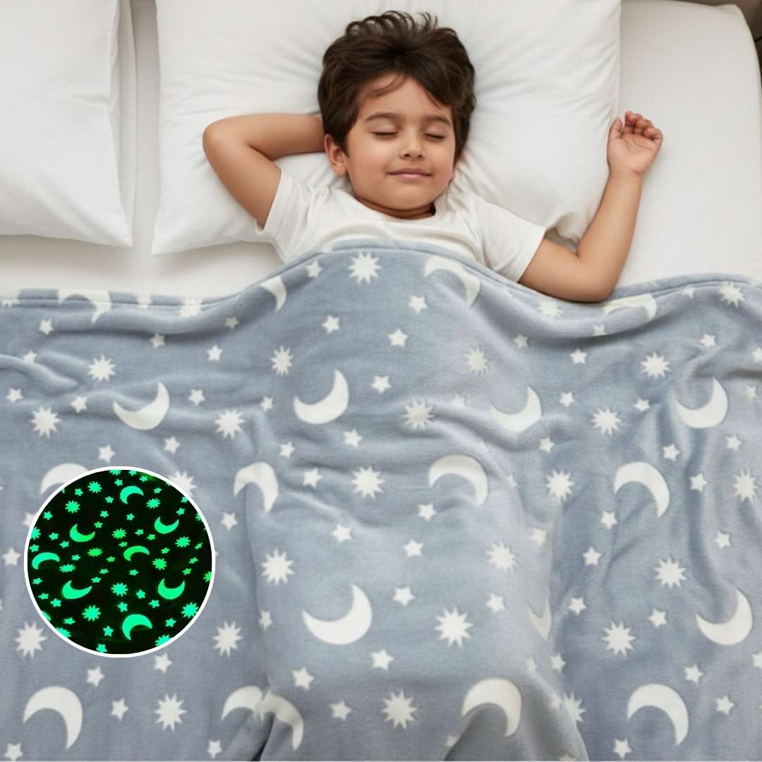 Child sleeping under a blanket with moon and star patterns, including a close-up of the glowing design.