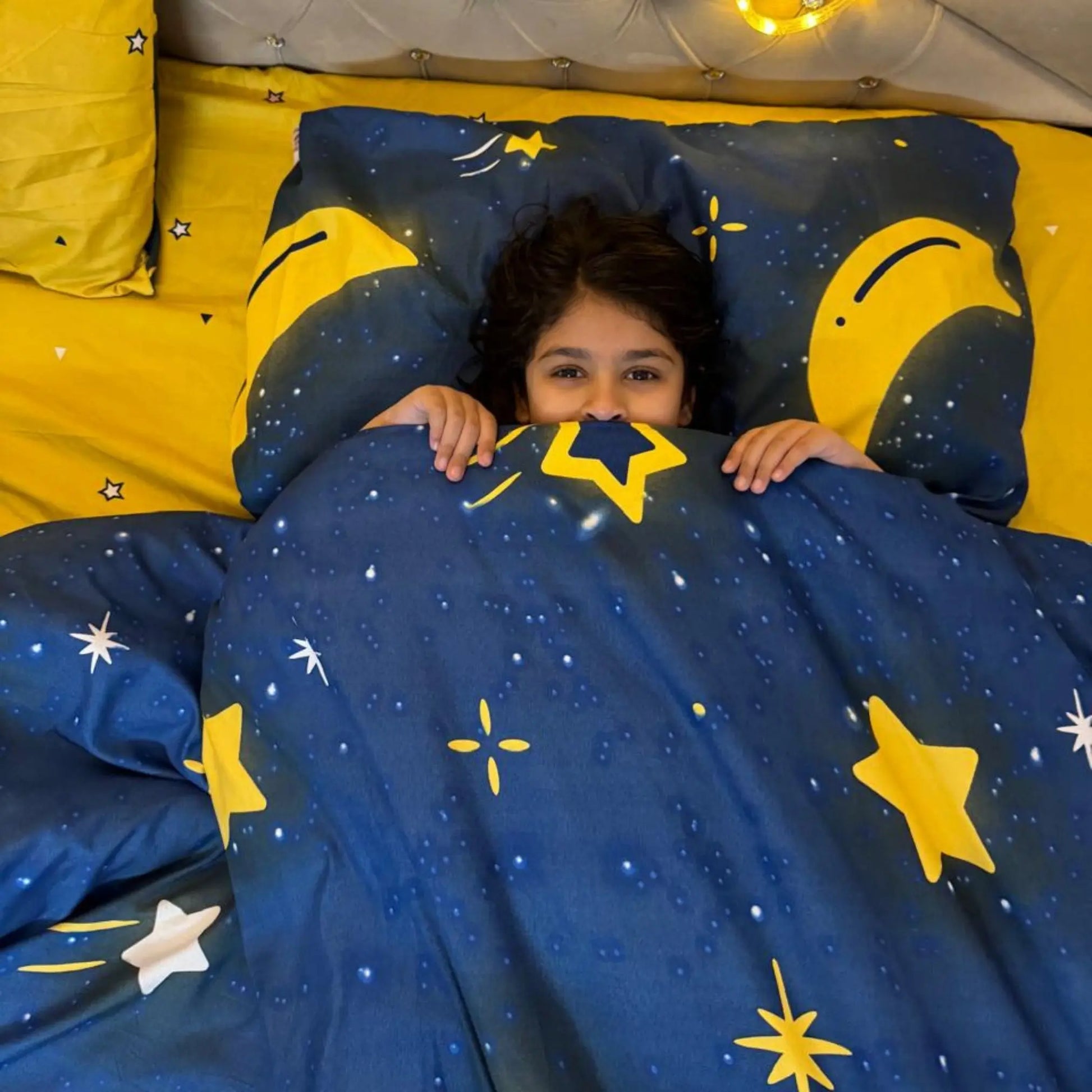 Reversible comforter in Moon and Stars design with blue and yellow accents, providing versatile decor options