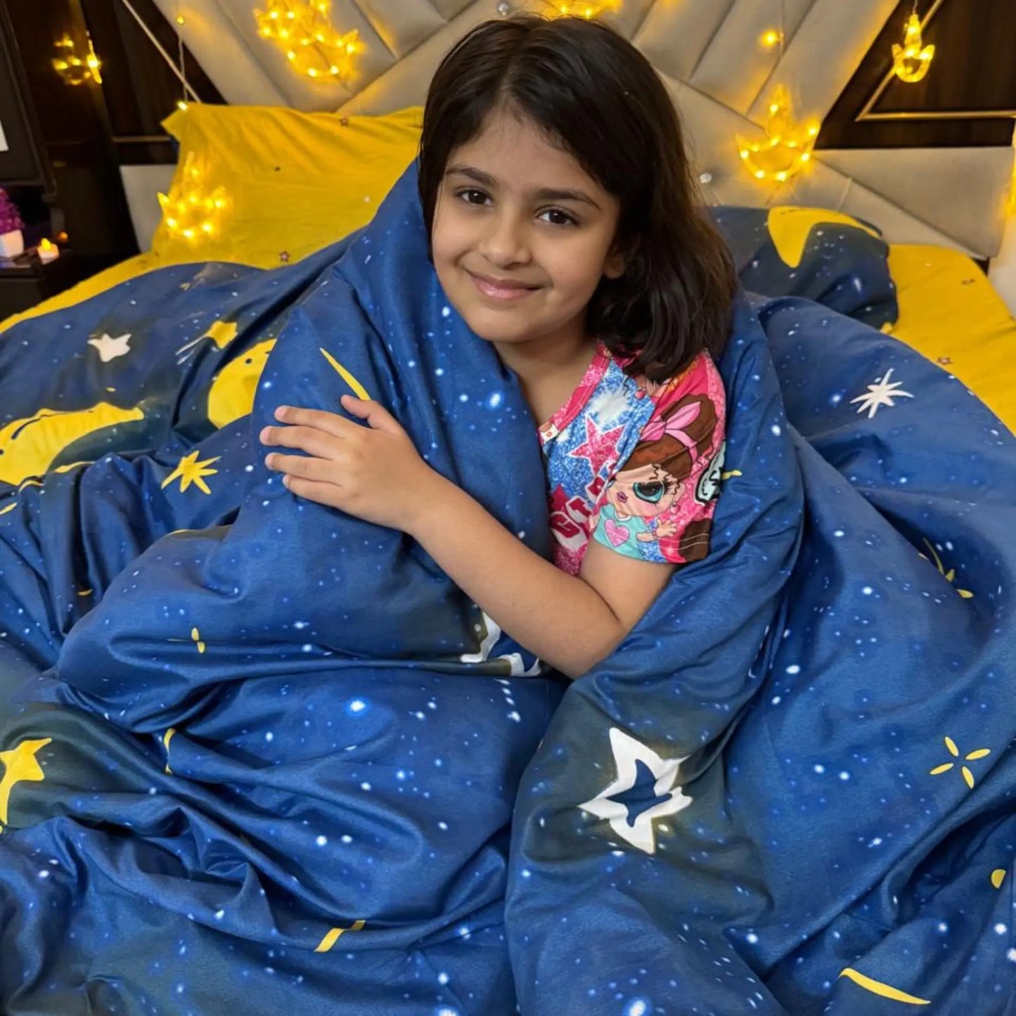 Child wrapped in the Famyo Moon and Stars comforter, enjoying its soft and cozy warmth