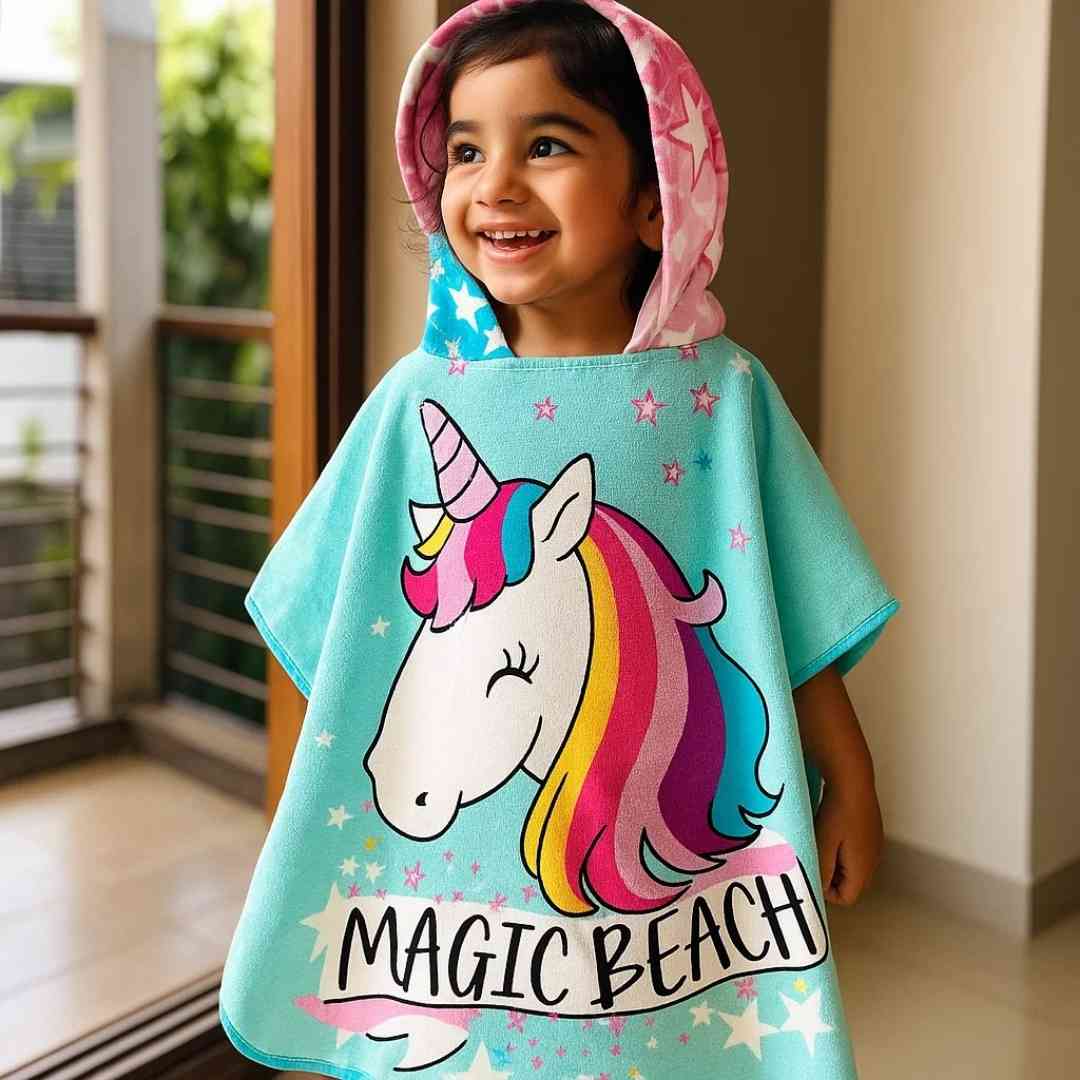Child wearing Famyo Magic Beach Pink Unicorn hooded towel for kids, ages 1–7 years. 100% microfiber bath towel with quick-drying fabric and vibrant unicorn design.