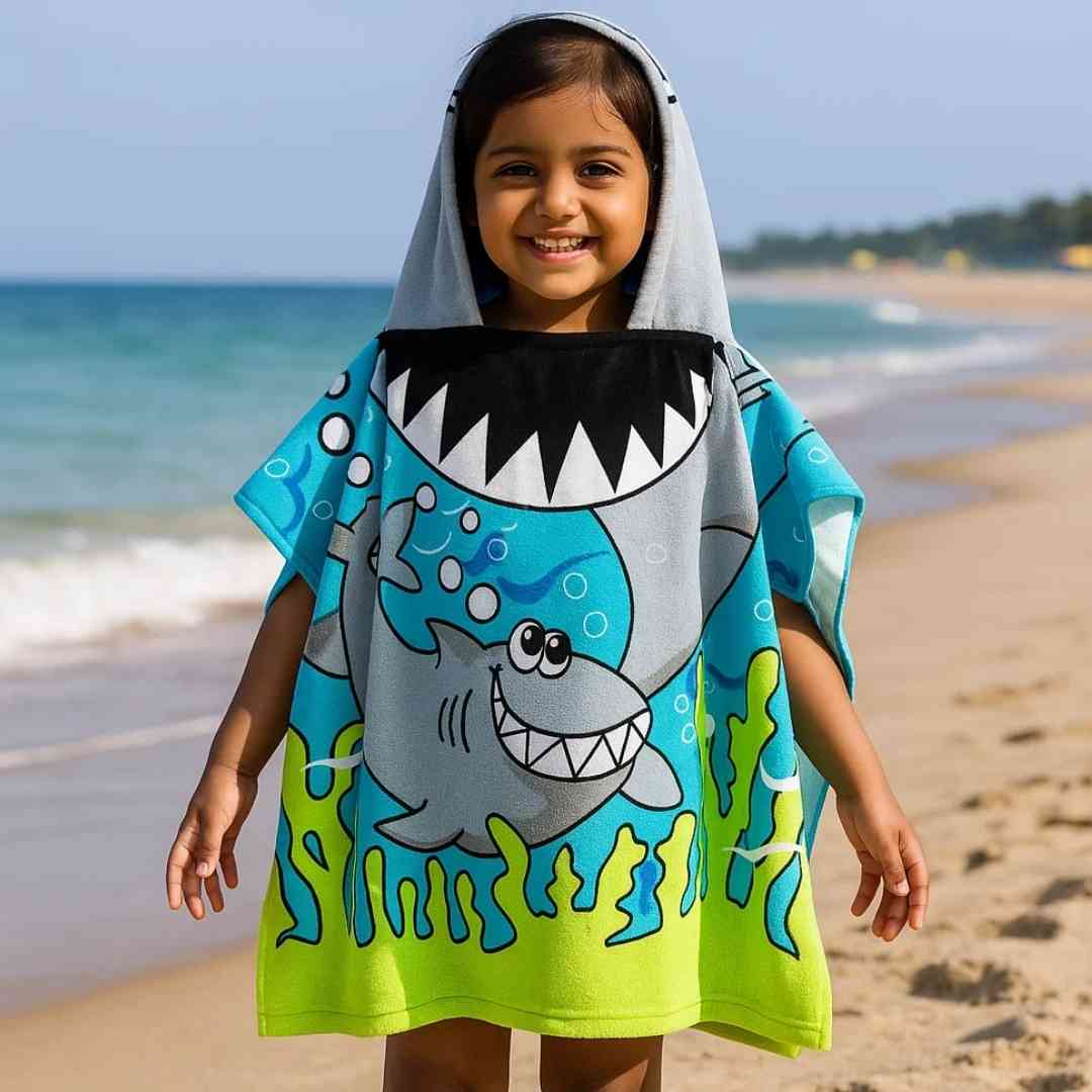 Child wearing Famyo Cute Shark poncho towel for kids, ages 1–7 years. Quick-drying microfiber hooded bath towel with playful shark design, ideal for bath, beach, or pool.